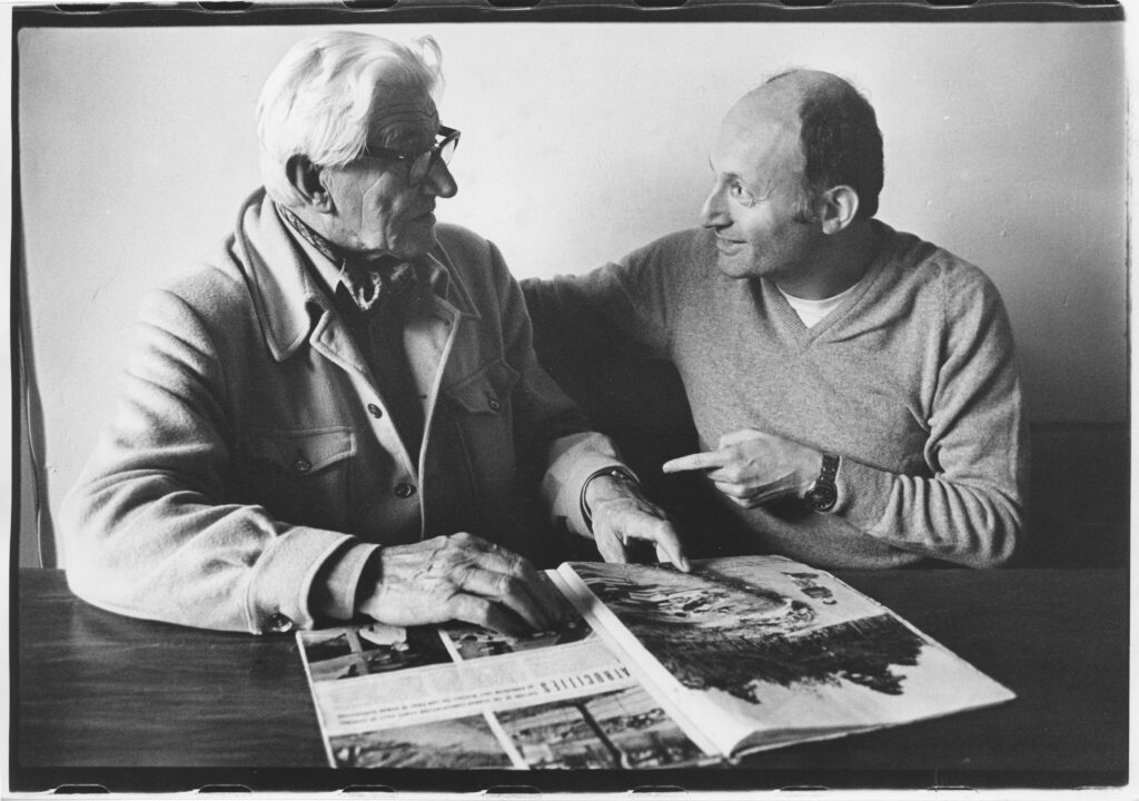 George Rodger (links) en Sieg (rechts) bekijken de fotoreportage in Life Magazine (1981).